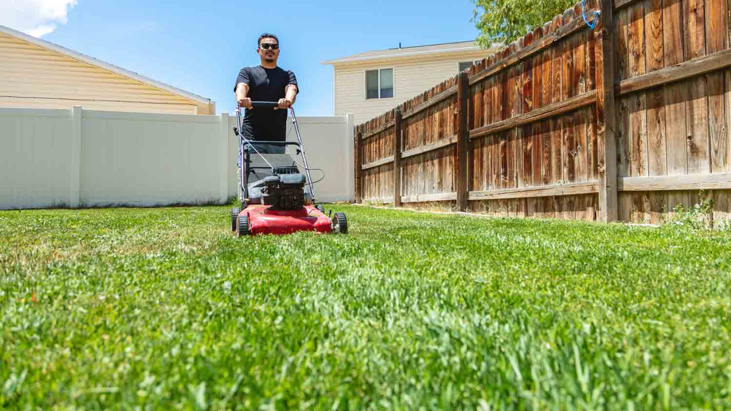 man mowing lawn in yard