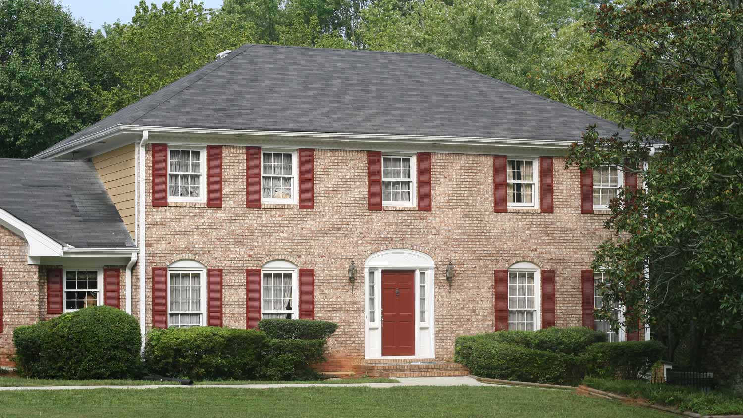 Brick house with red trim including different tones of red paint