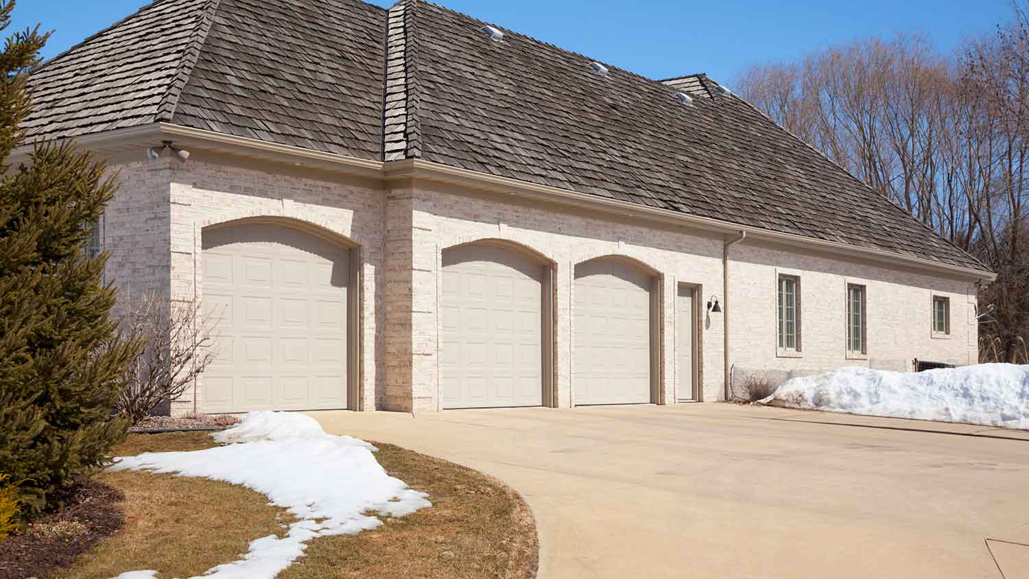 White brick house with three stall garage