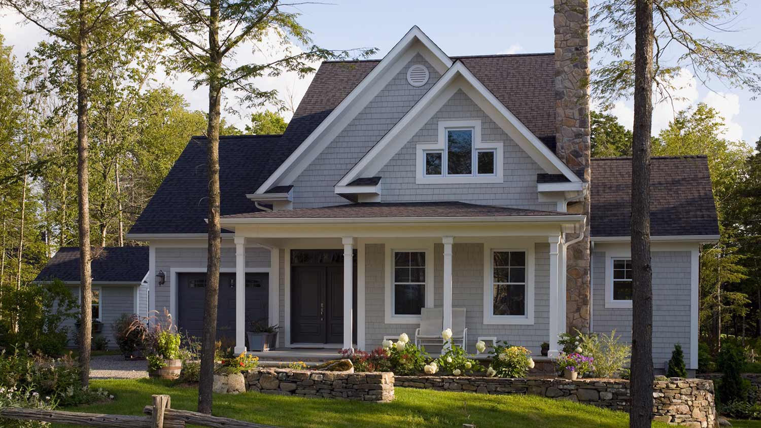 Grey home in a pretty shaded setting with trees