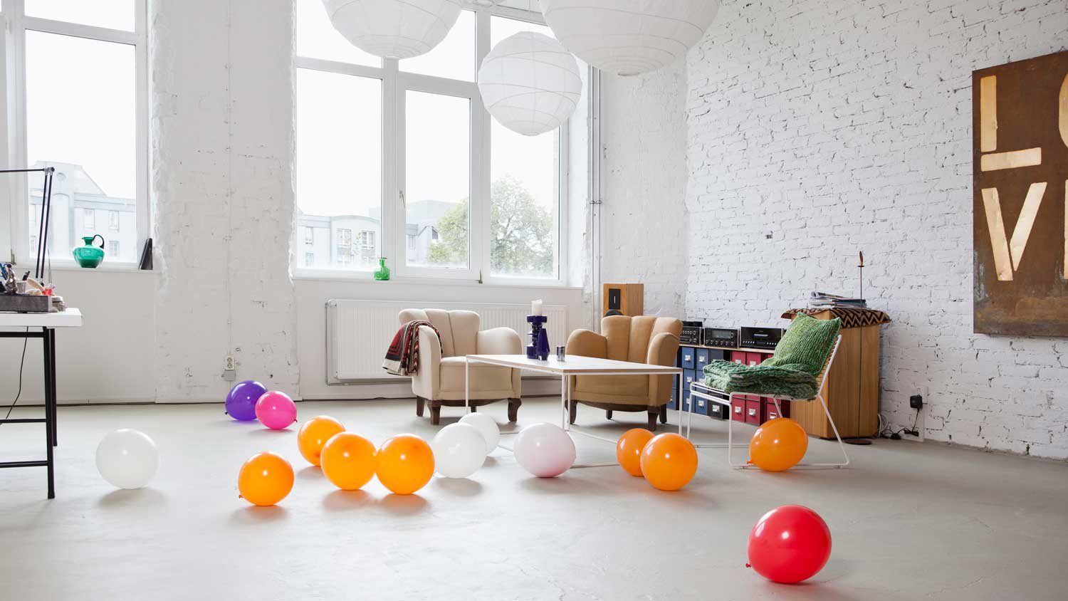An open-space living room with a white brick wall