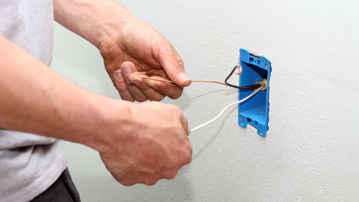 electrician holding neutral wires in outlet