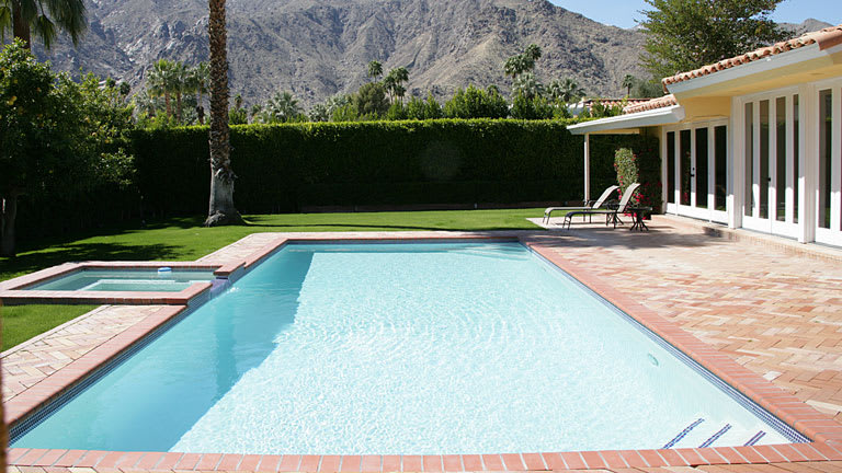Home swimming pool in backyard with view of mountains in distance