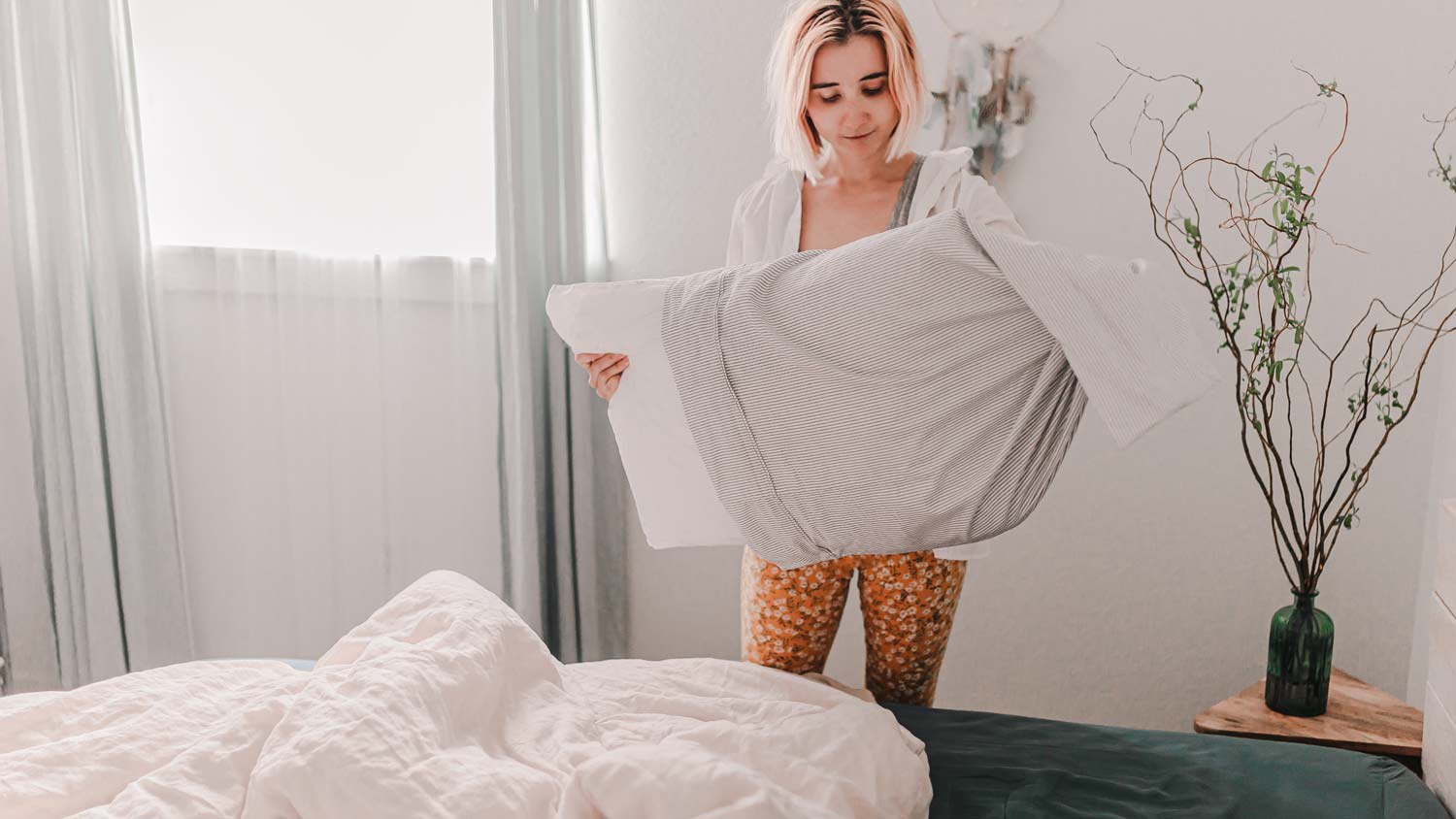 woman changing bed sheets
