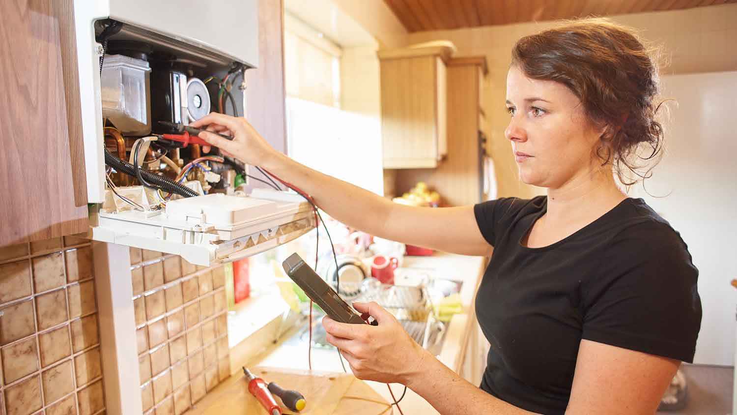Female technician repairing electric water heater