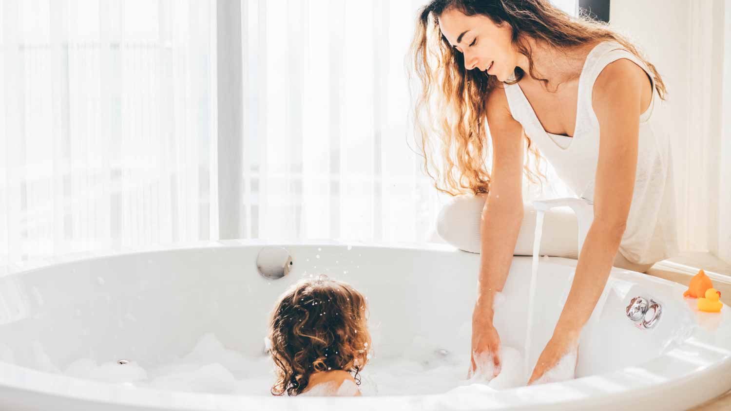 Mother and child having bubble bath