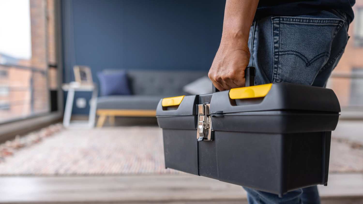 Close-up on an electrician carrying a toolbox