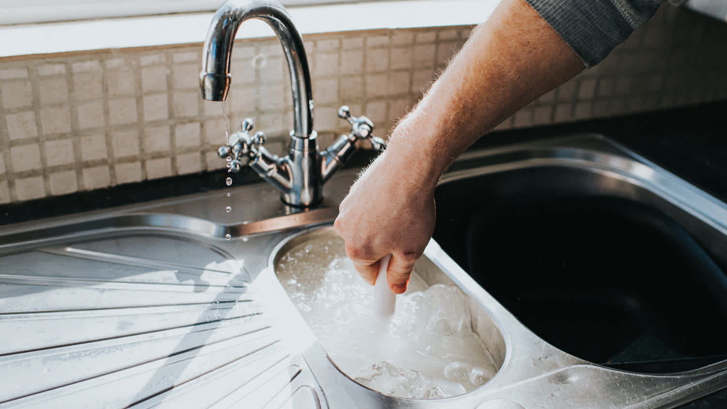 Man fixing kitchen sink clog