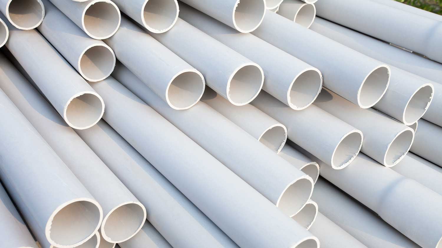 White PVC pipes piled up on the floor