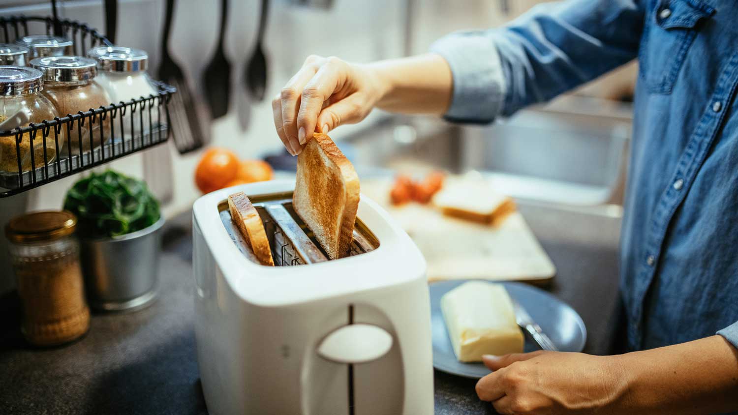 A woman toasting bread in the toaster