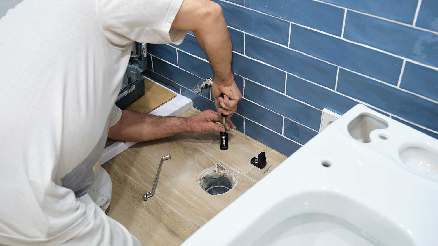 Plumber installing new toilet drain line