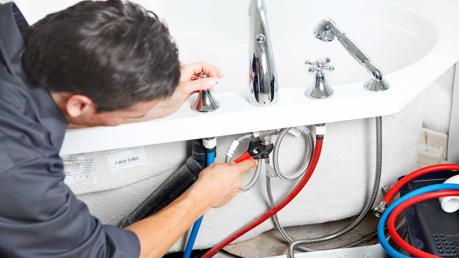 Man installing bathtub supply lines