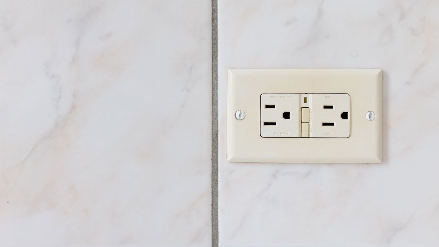 GFCI electrical outlet installed on a tiled wall