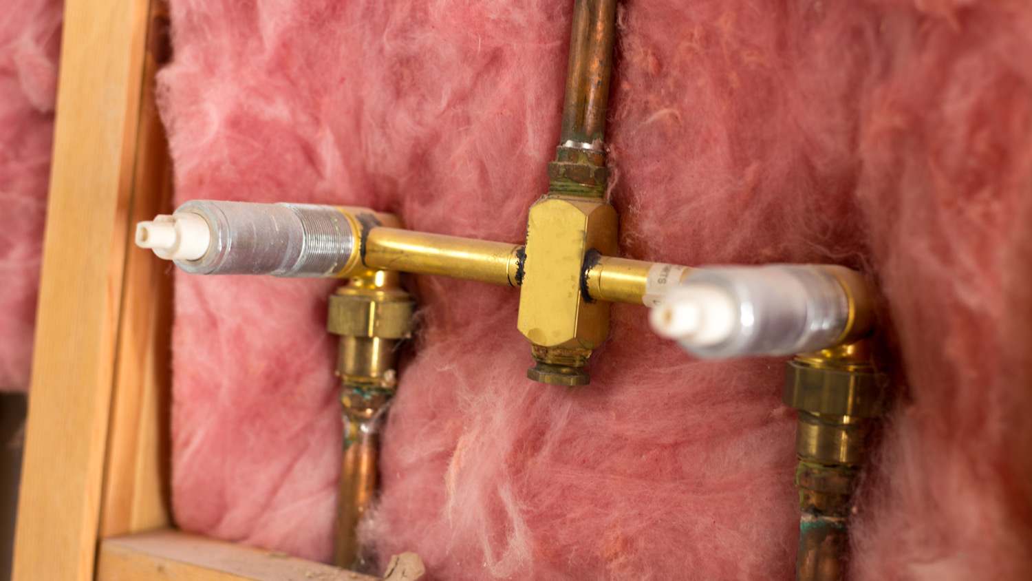 Bathroom pipe sink surrounded by fiberglass insulation