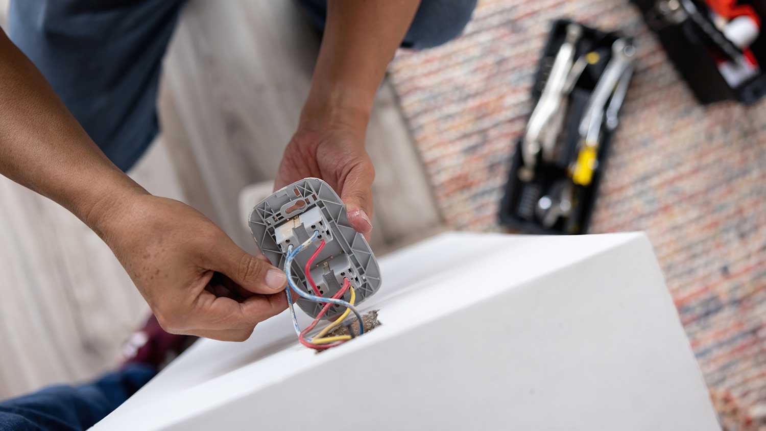 Electrician fixing wires in the electrical outlet