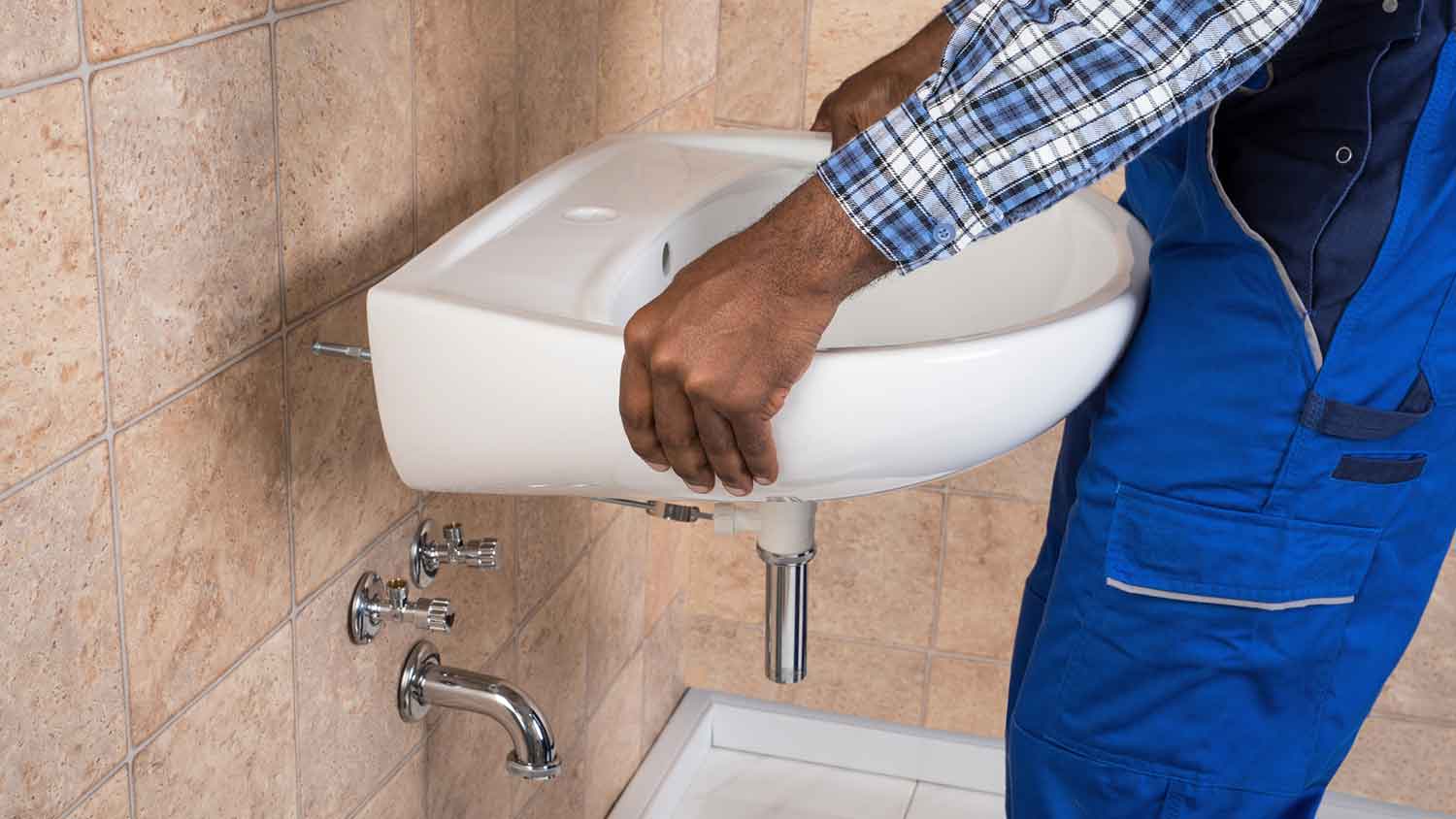 Handyman installing bathroom wall-mount sink