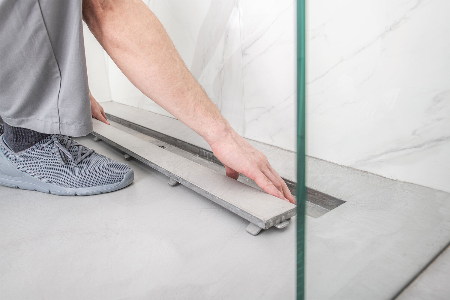 man installing linear drain