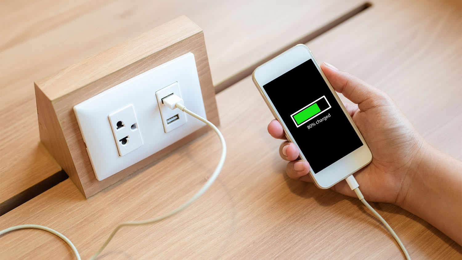 Hand holding charging smartphone