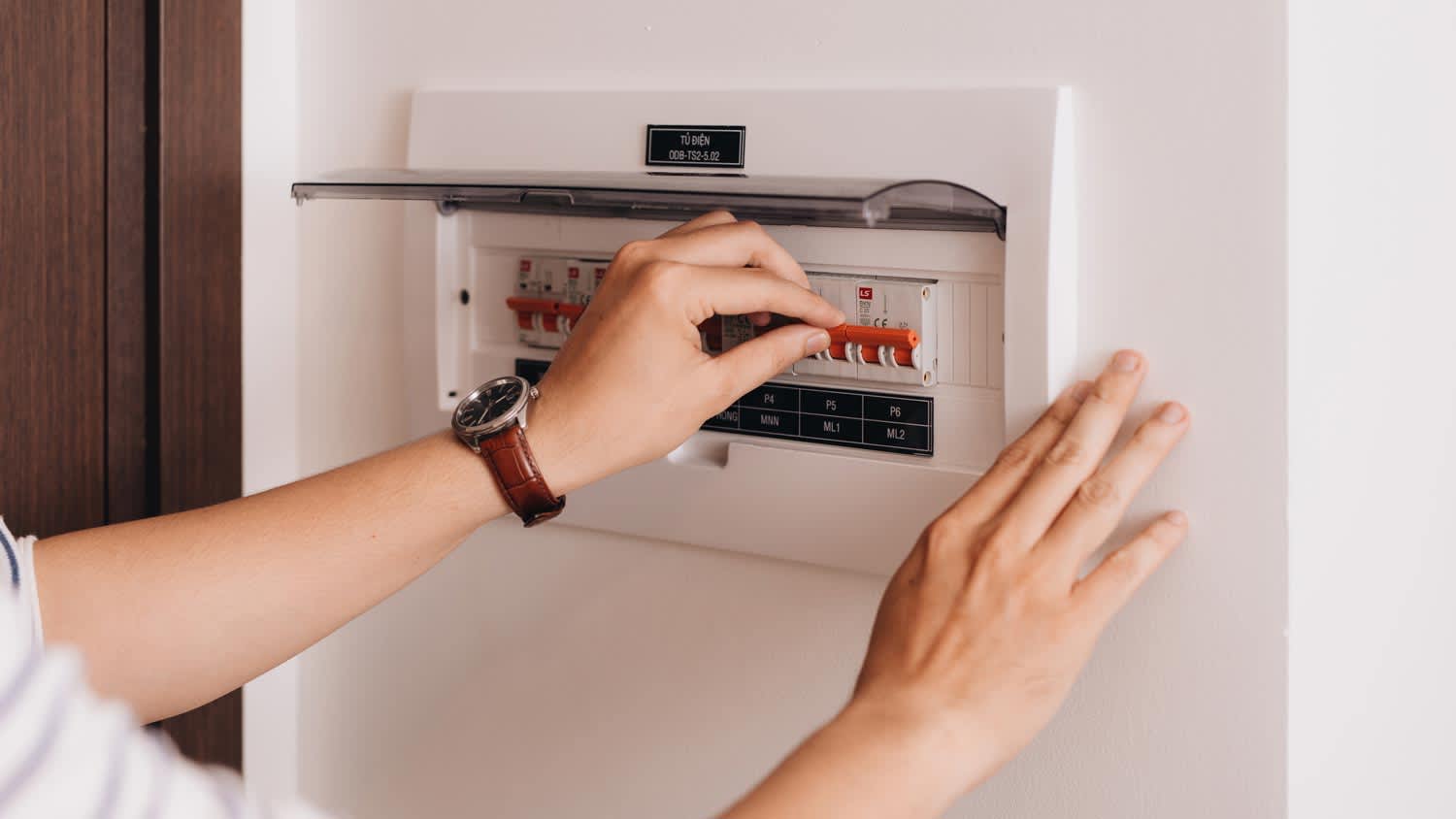 A person shutting down the power on the circuit breaker