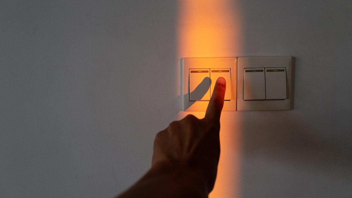 A hand turning on a light