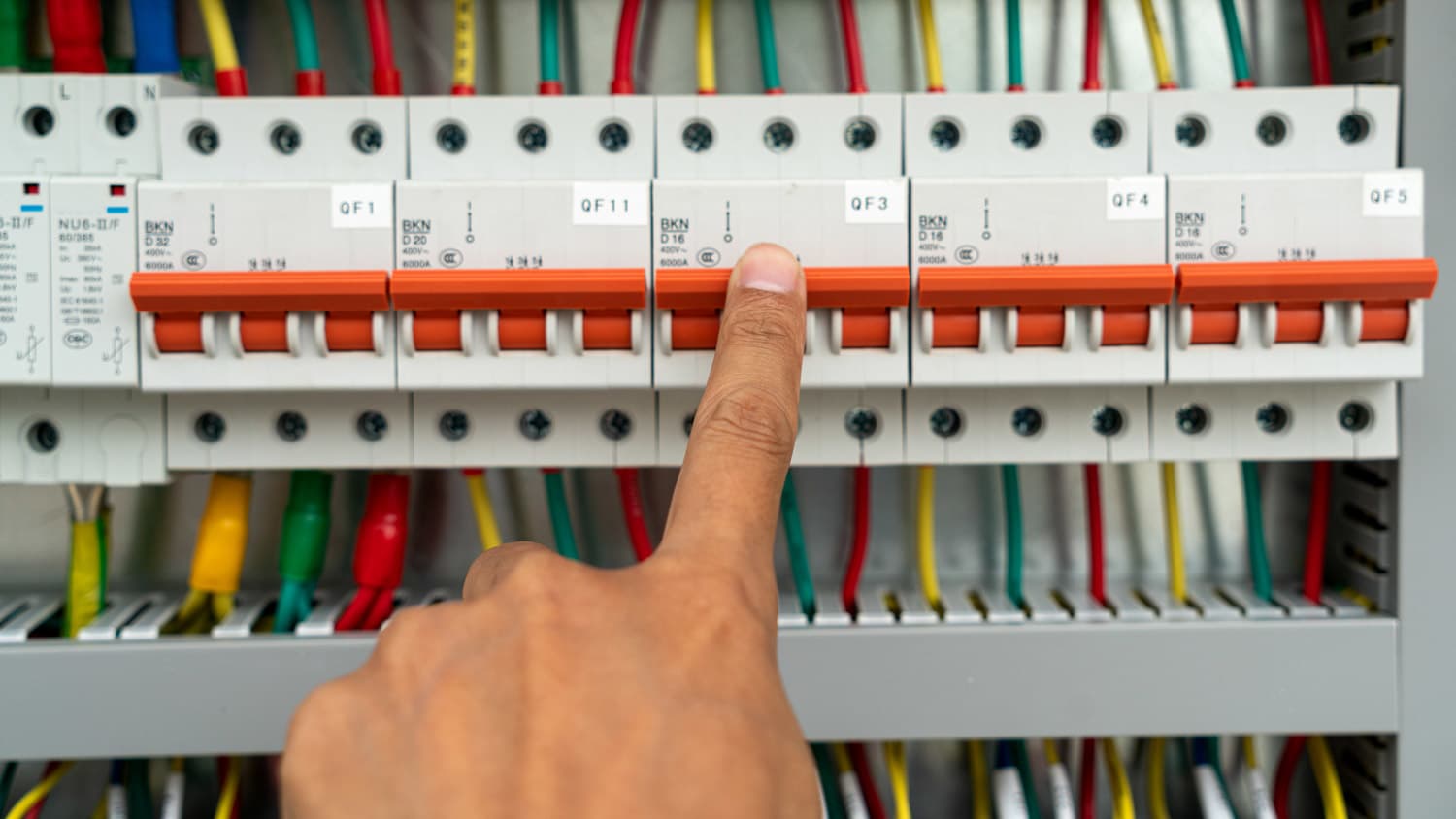 Close-up of a finger flipping the circuit breaker