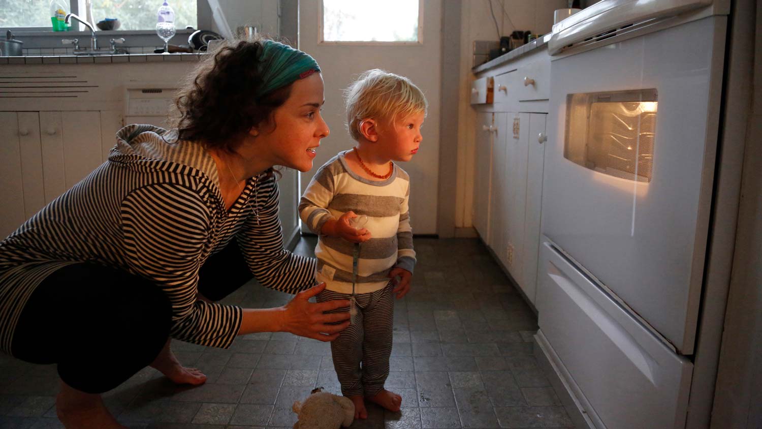A mother and her son looking in the oven window