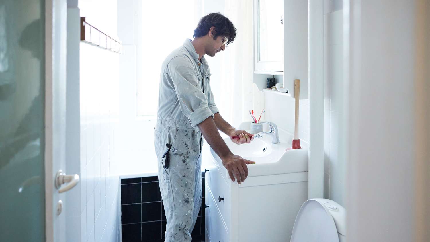 A plumber installing new bathroom faucet