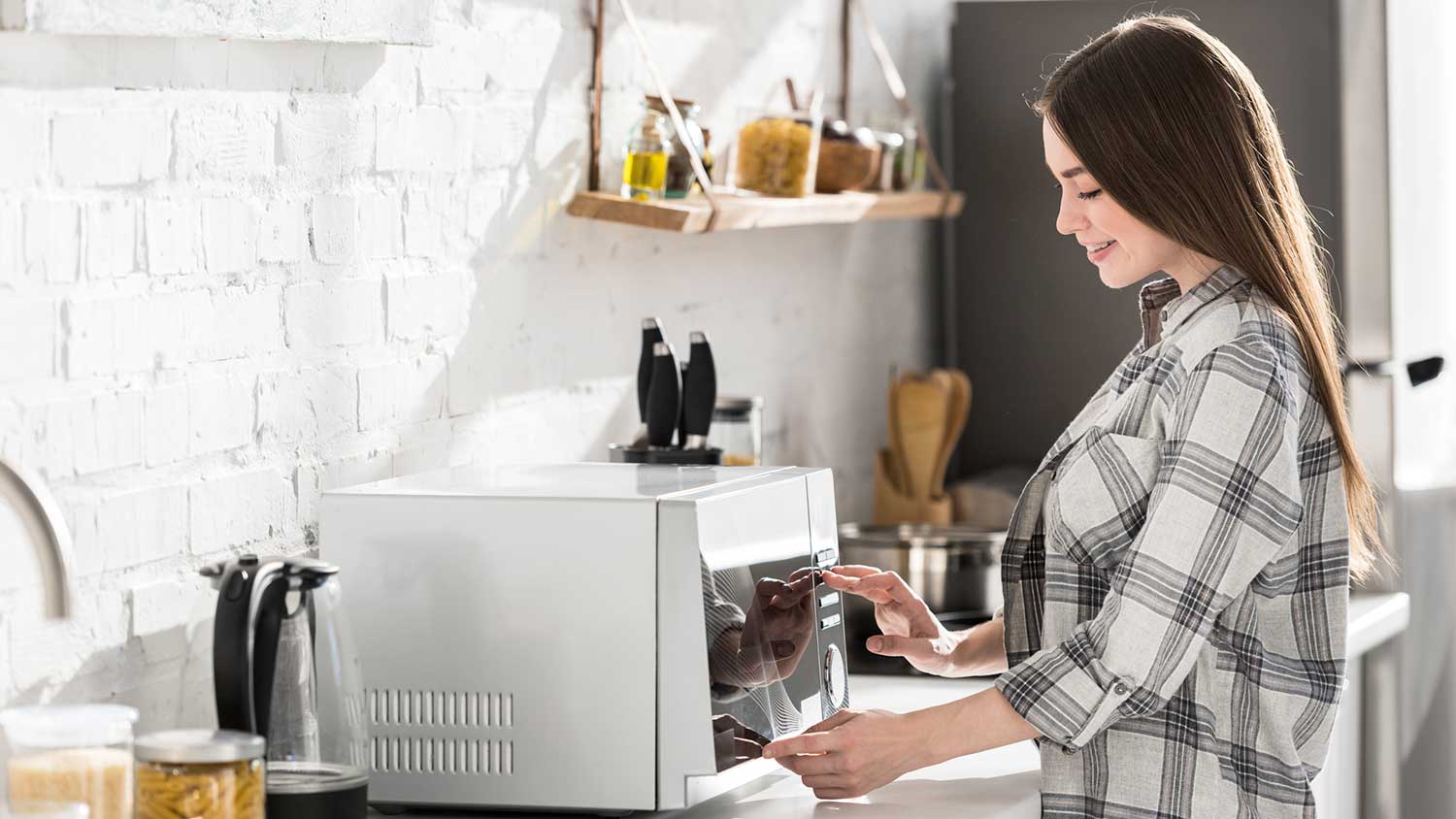 Woman in the kitchen setting up new microwave