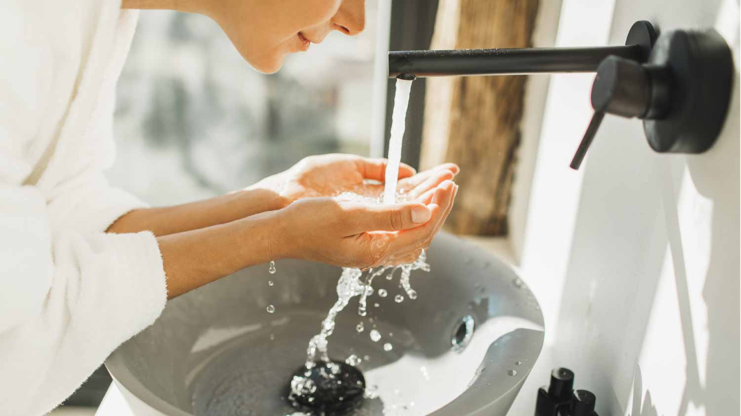 Woman washing and cleaning her face