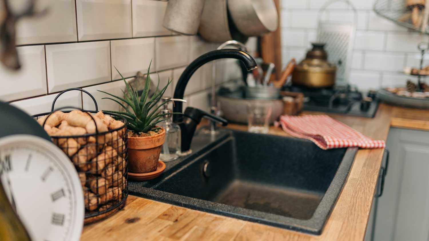 A black sink in a modern kitchen with wooden countertops