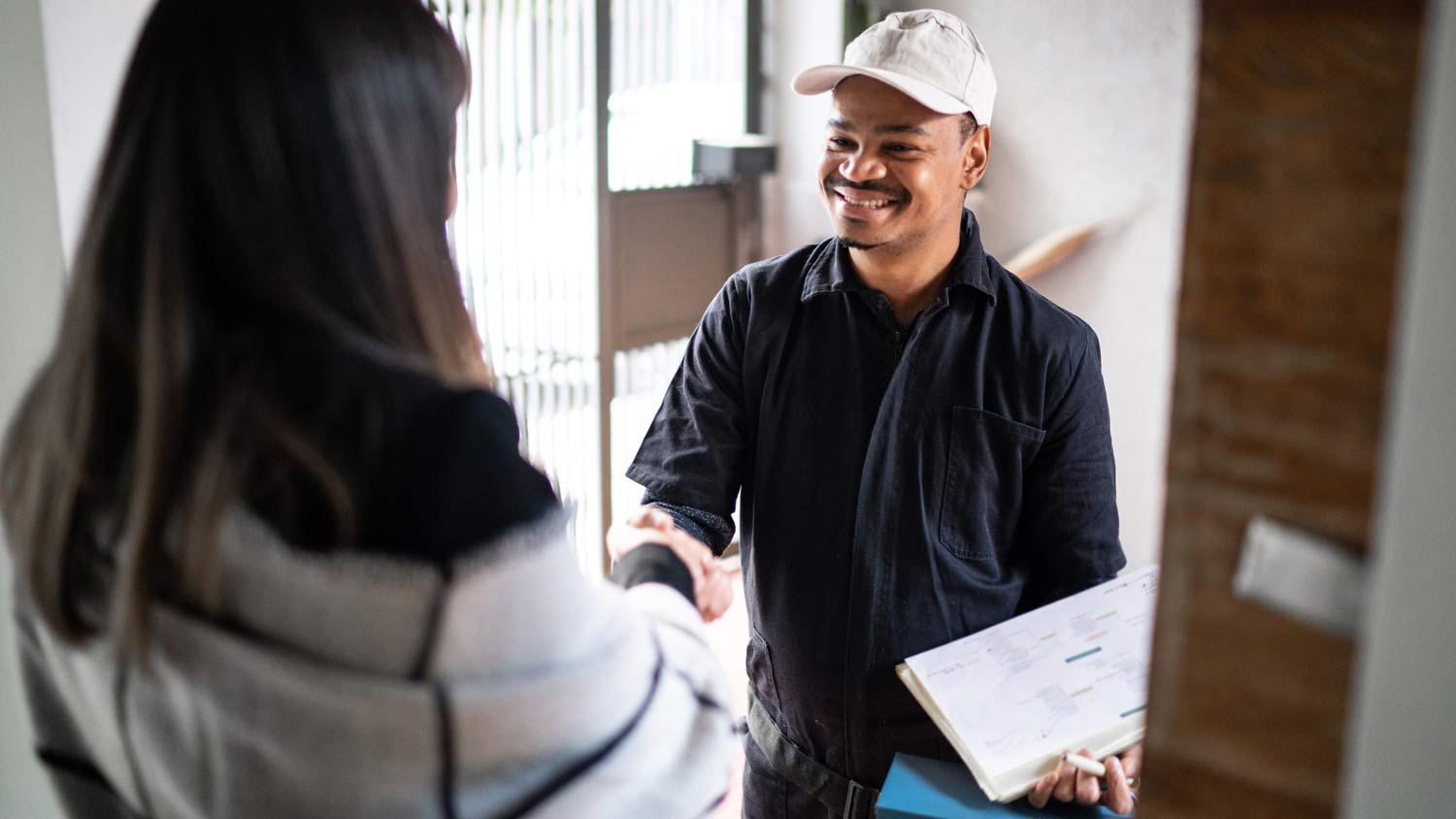 technician shaking hands with customer in home