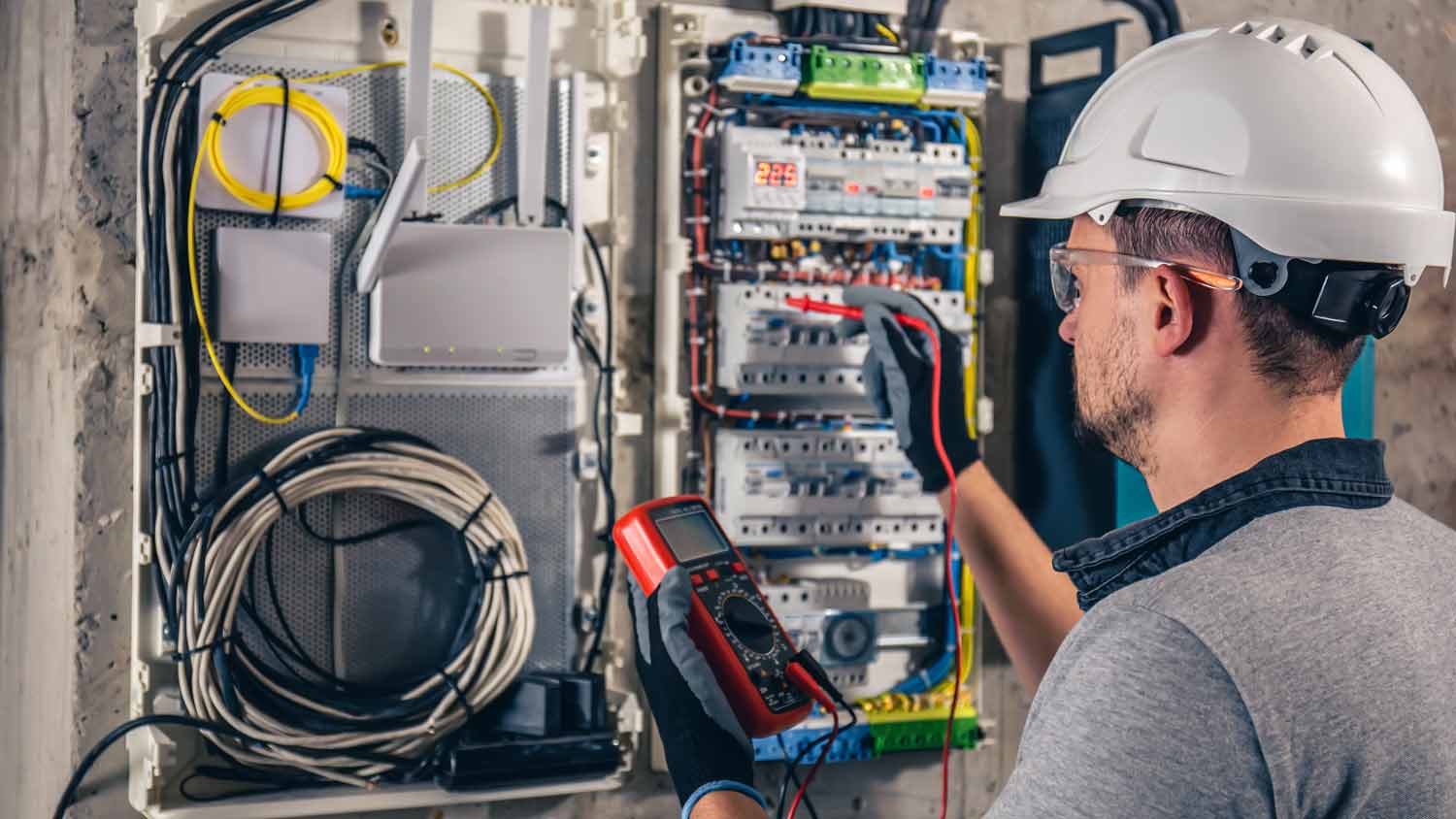 electrical technician working on switchboard in home