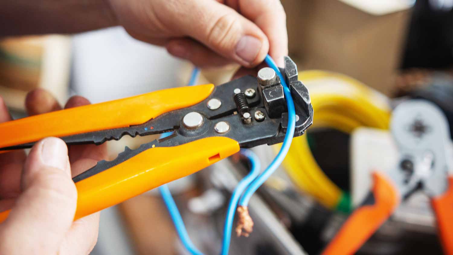 A electrician using wire stripping pliers