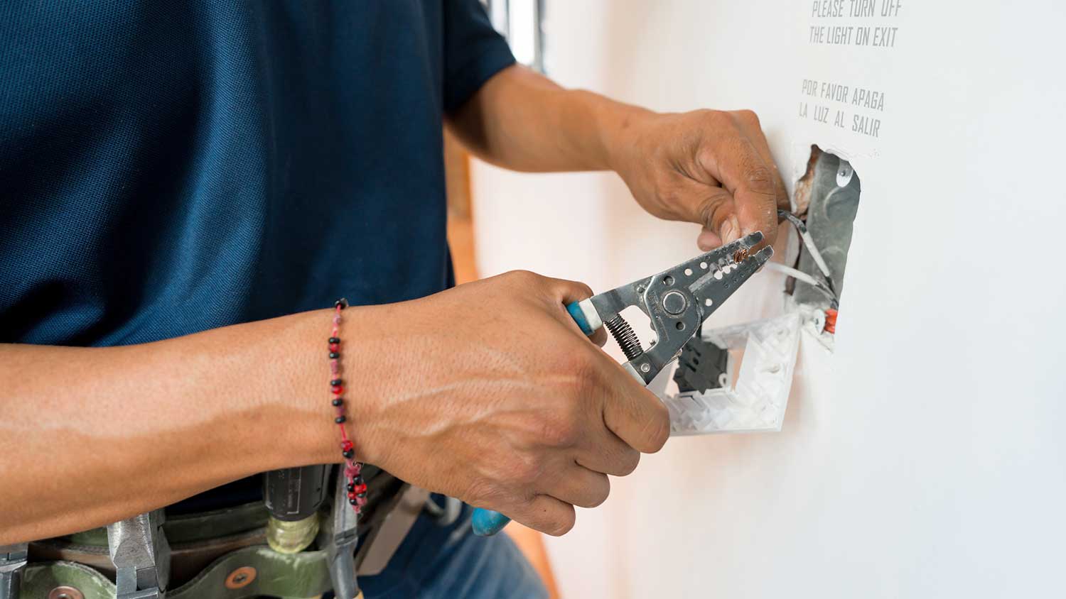 Handyman wiring electrical outlet in a house