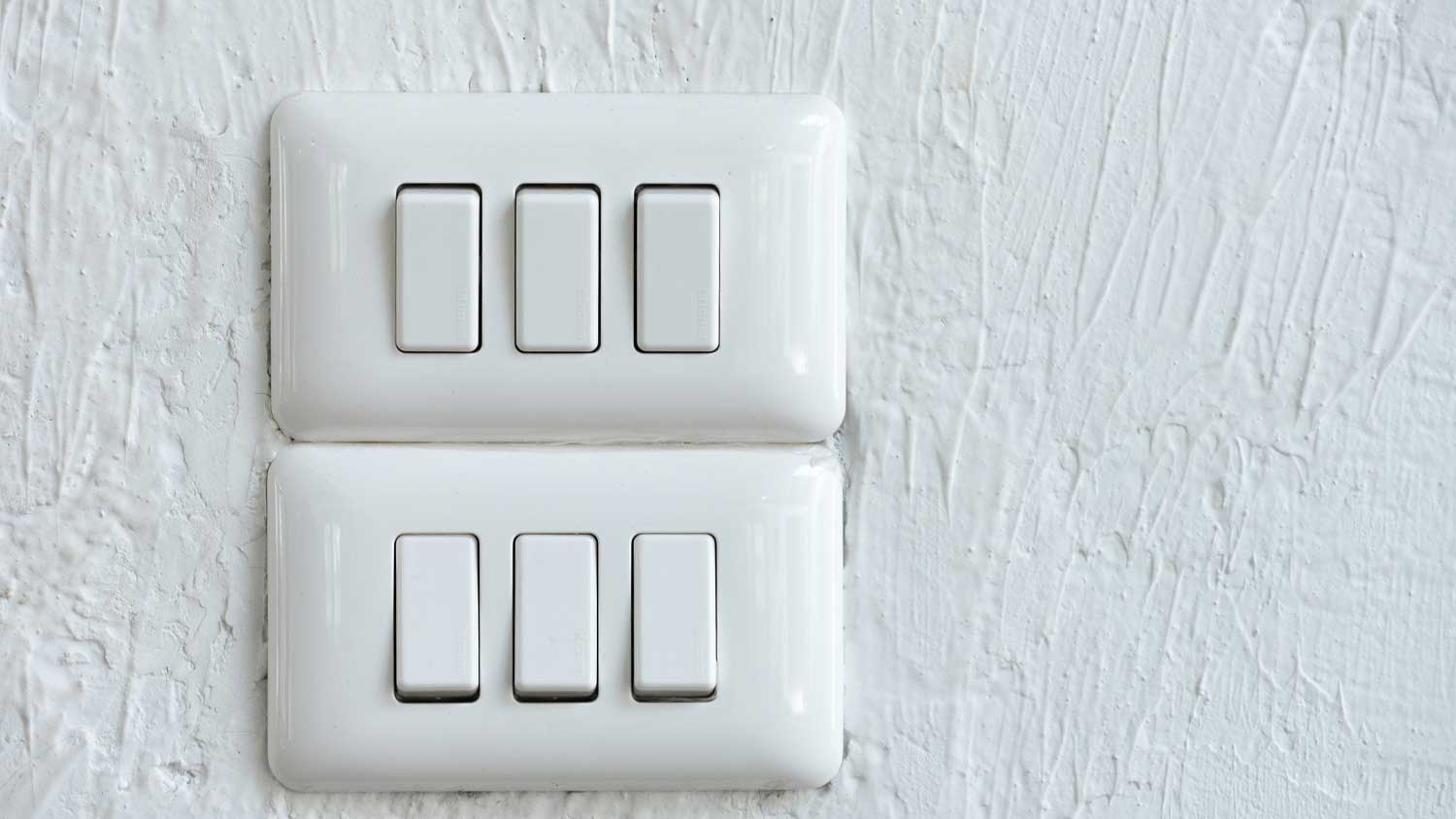 Triple switches mounted on a white wall