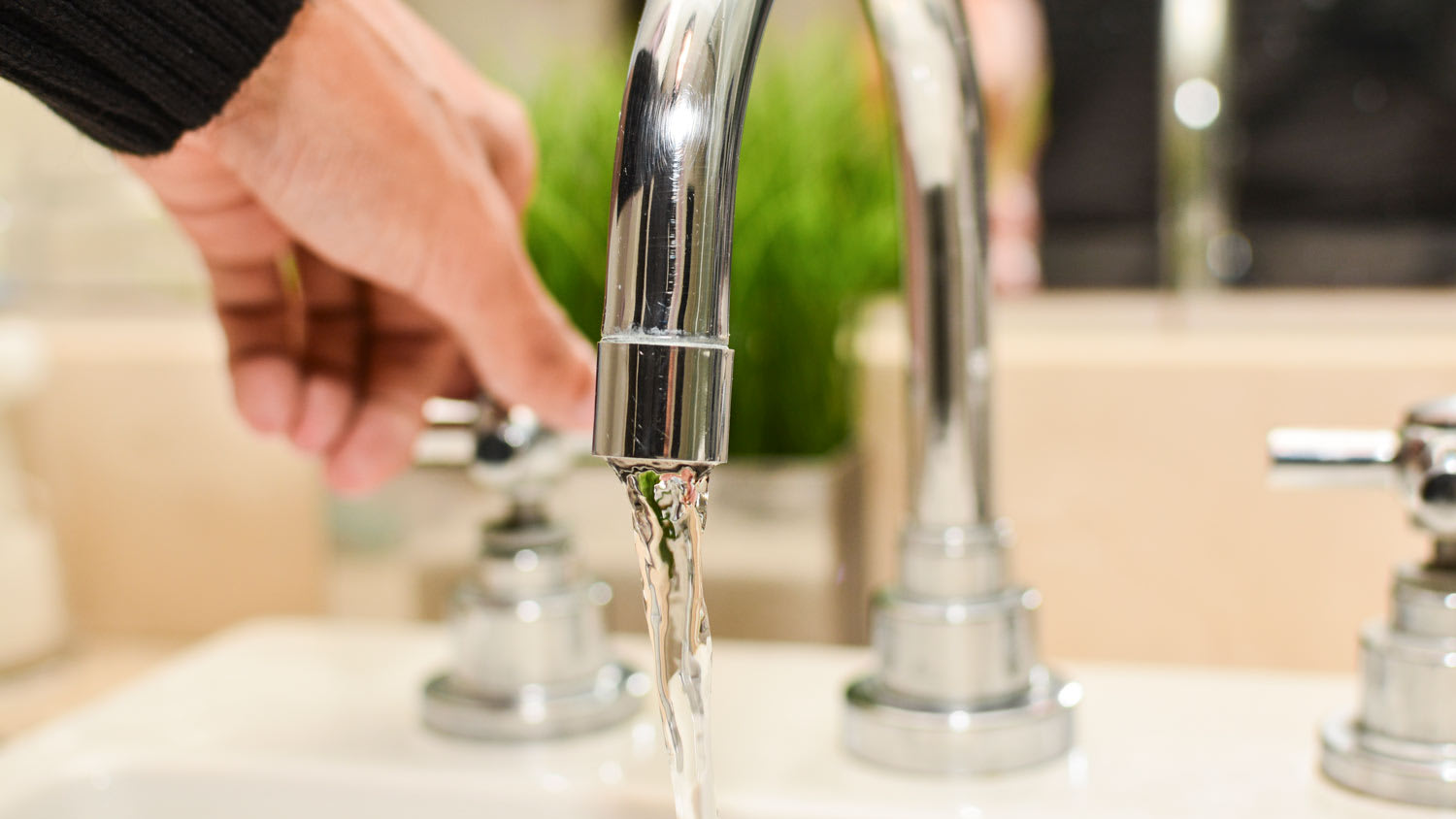 man opening bathroom faucet