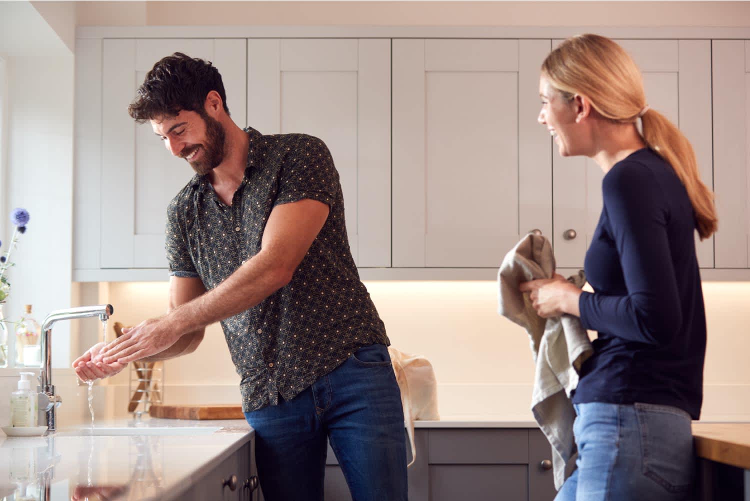 Couple washing hands with soap at home