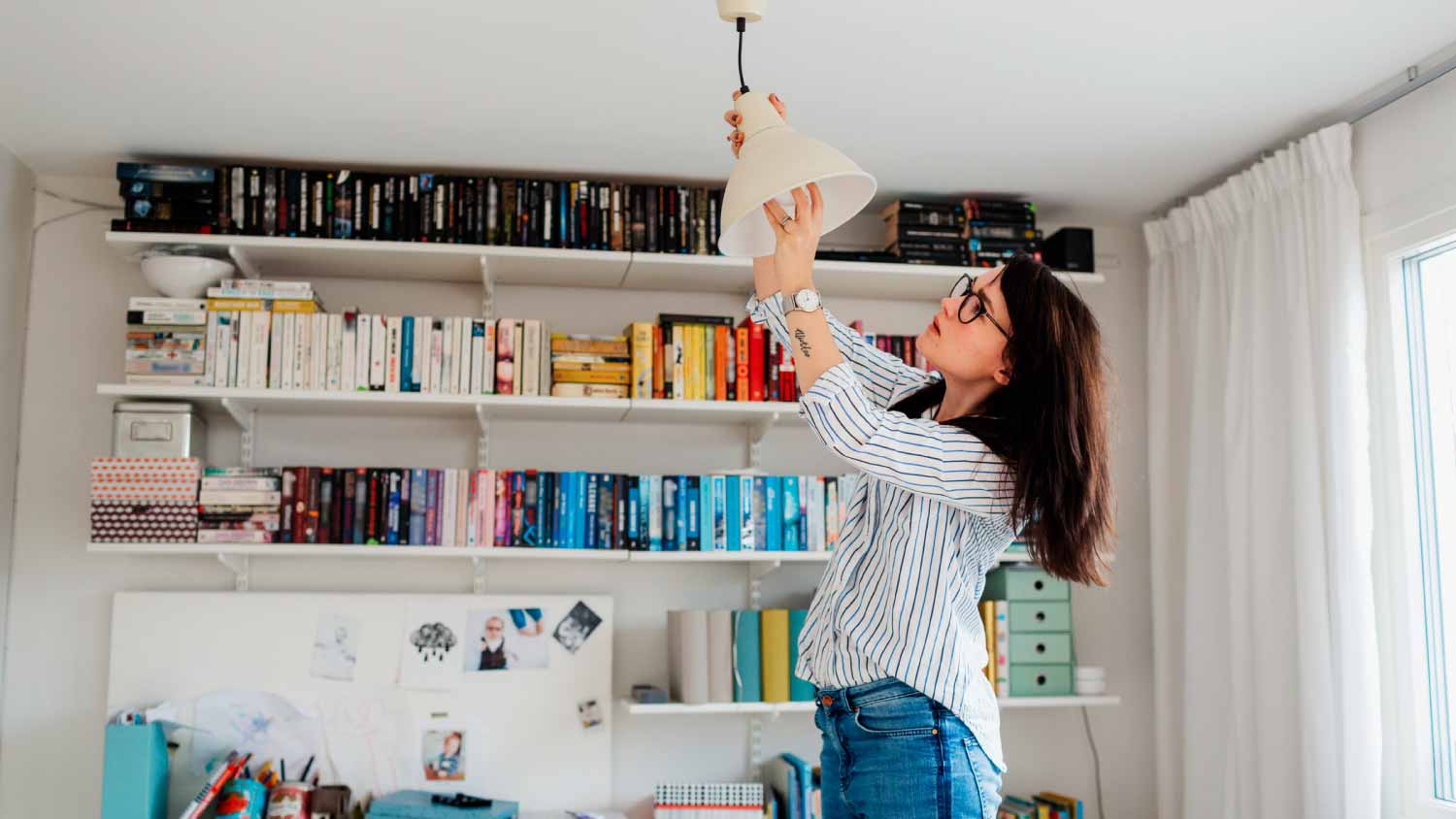 Woman changing bulb in house