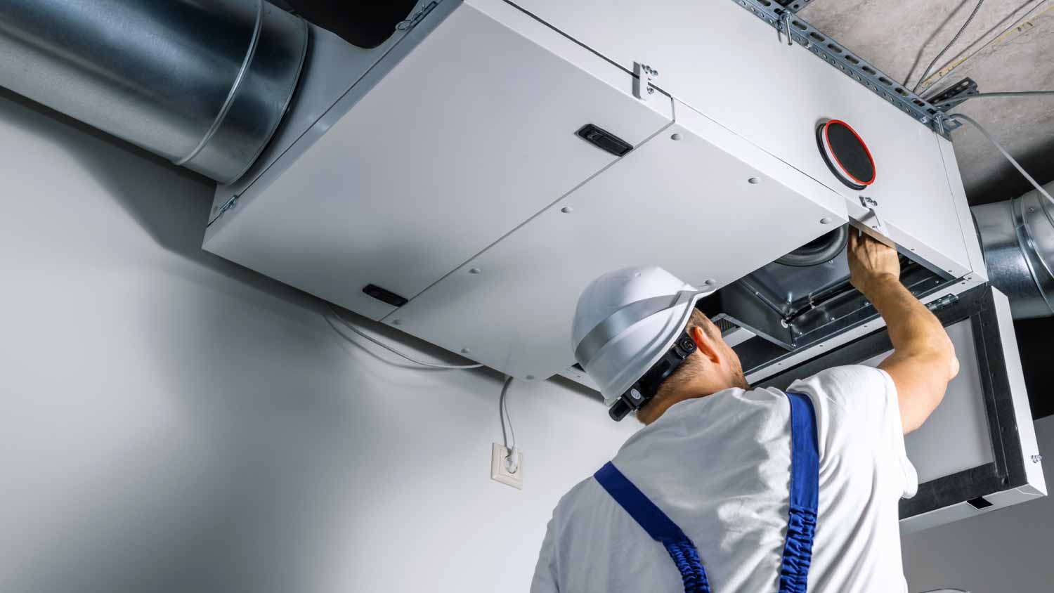 Engineer installing heat recovery ventilation system