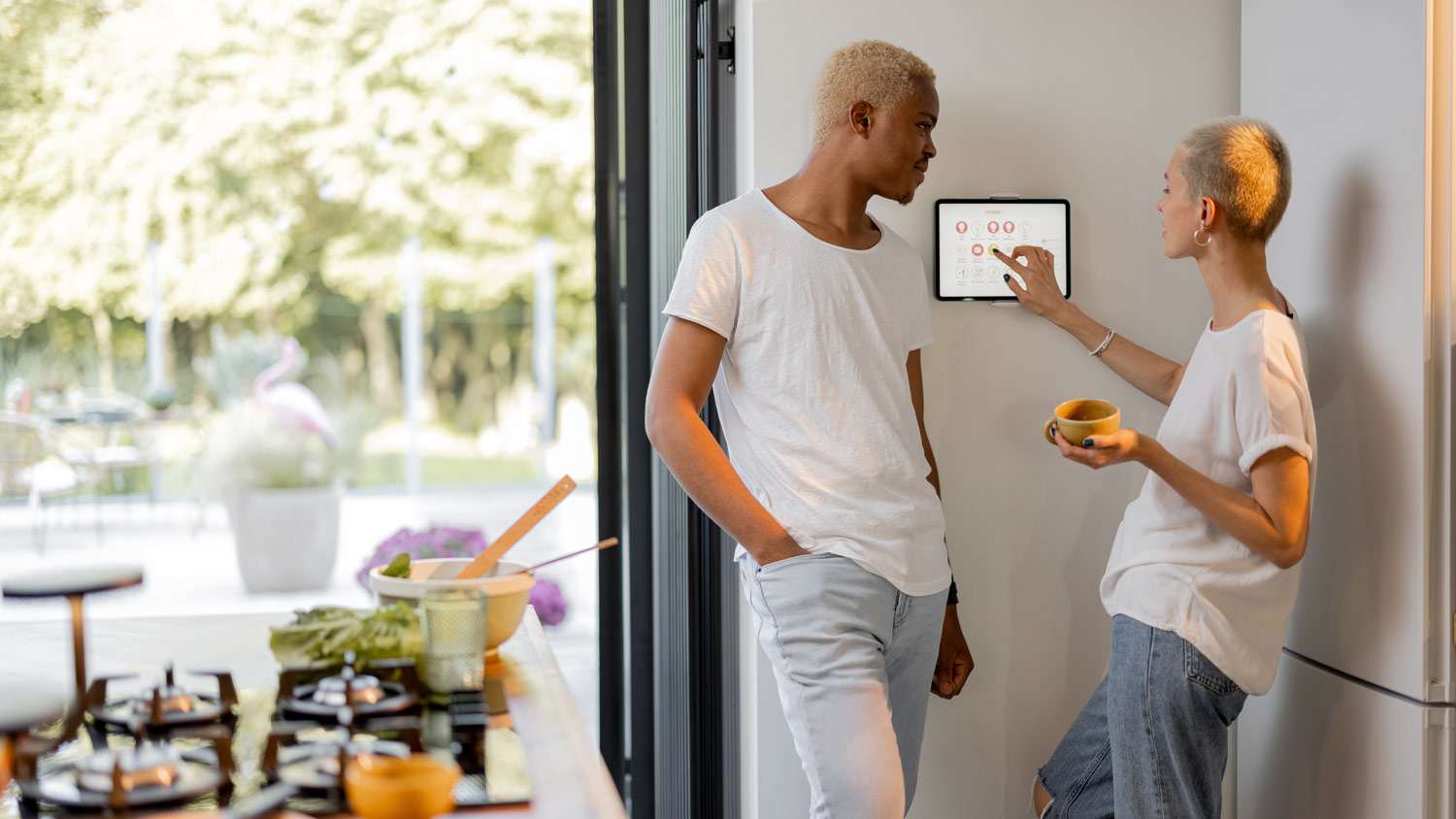 A young couple talking while woman using the thermostat