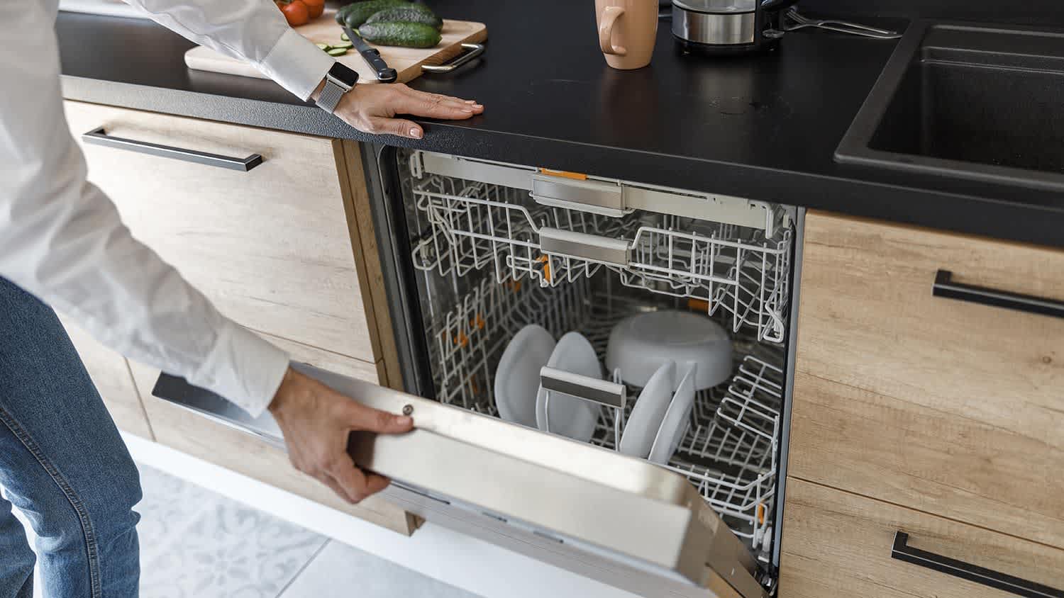 Opening dishwasher in kitchen