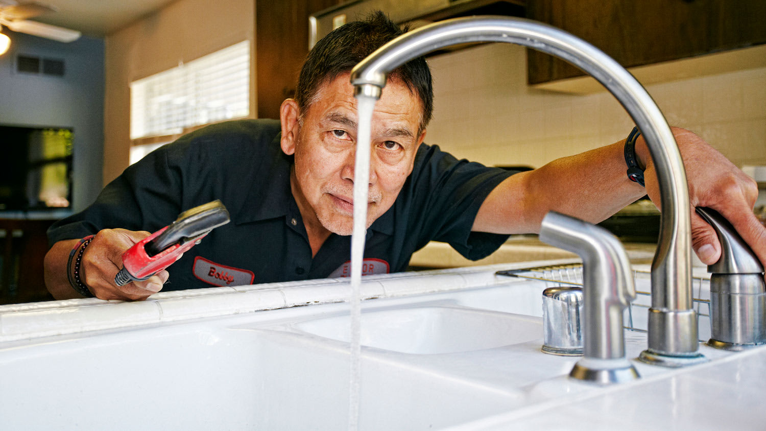 Plumber inspecting water flow