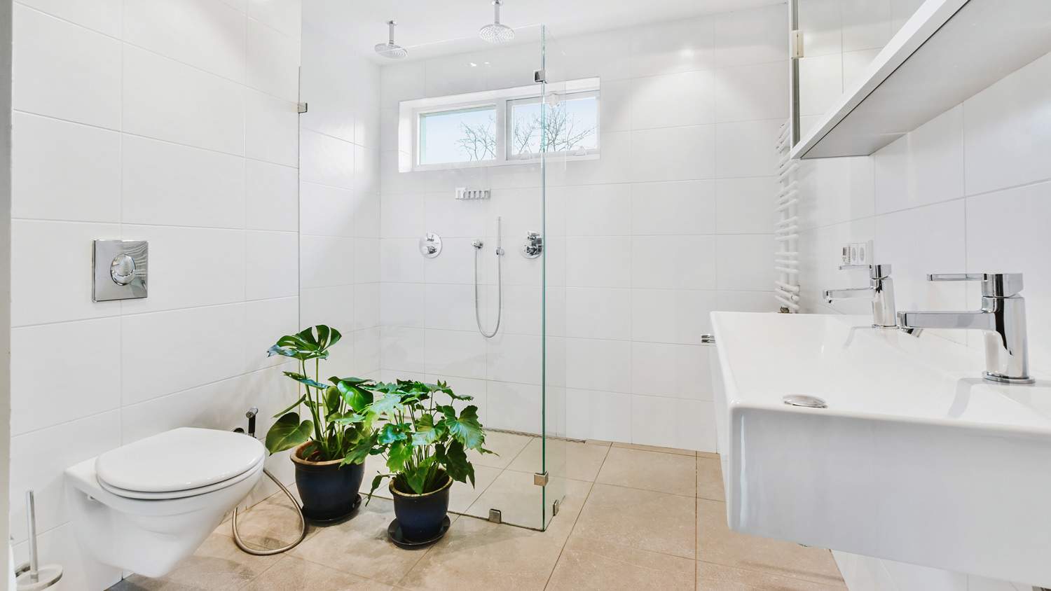 A bright bathroom with a glass shower cabin