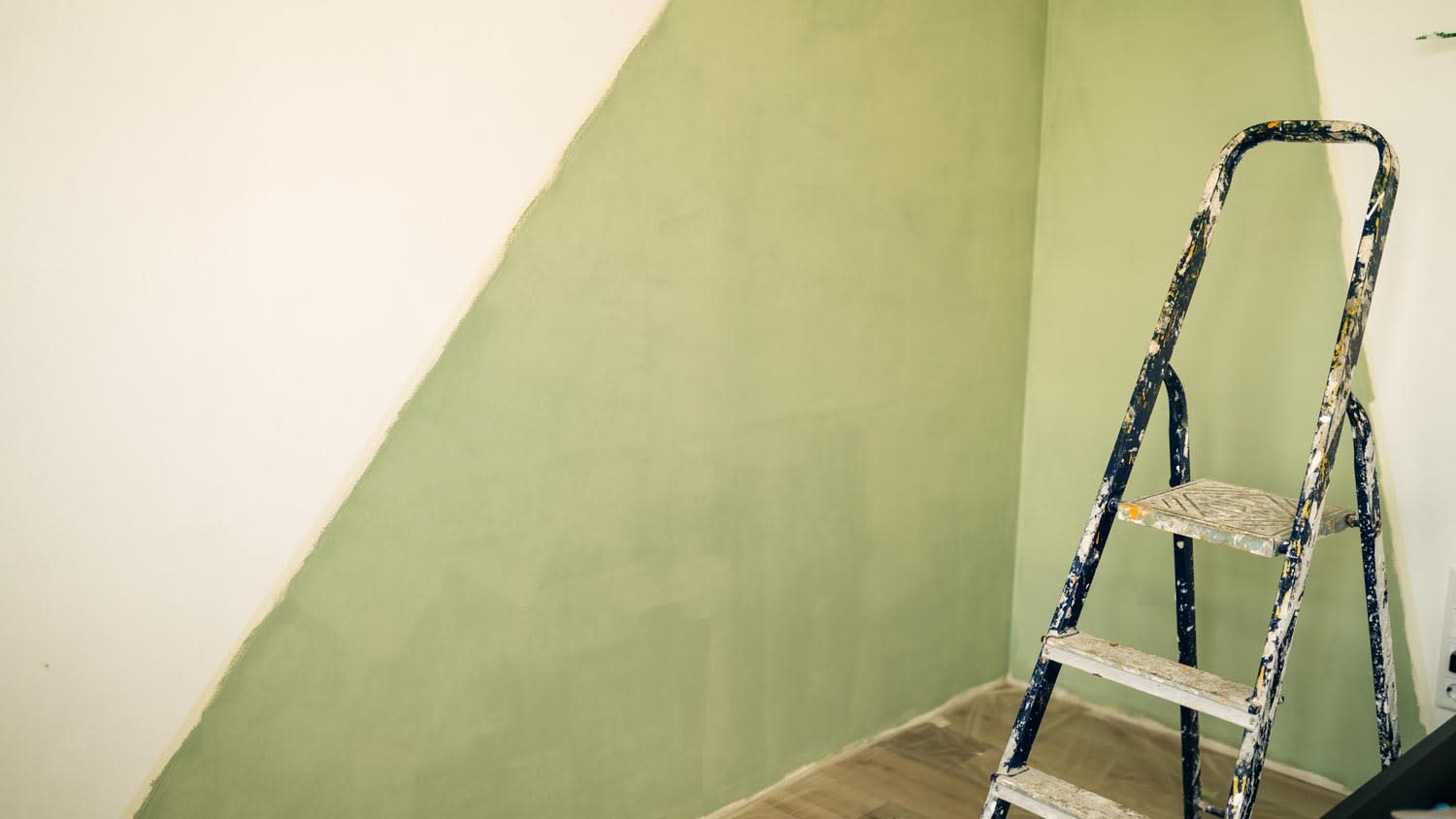 A room’s wall half painted in a diagonal form