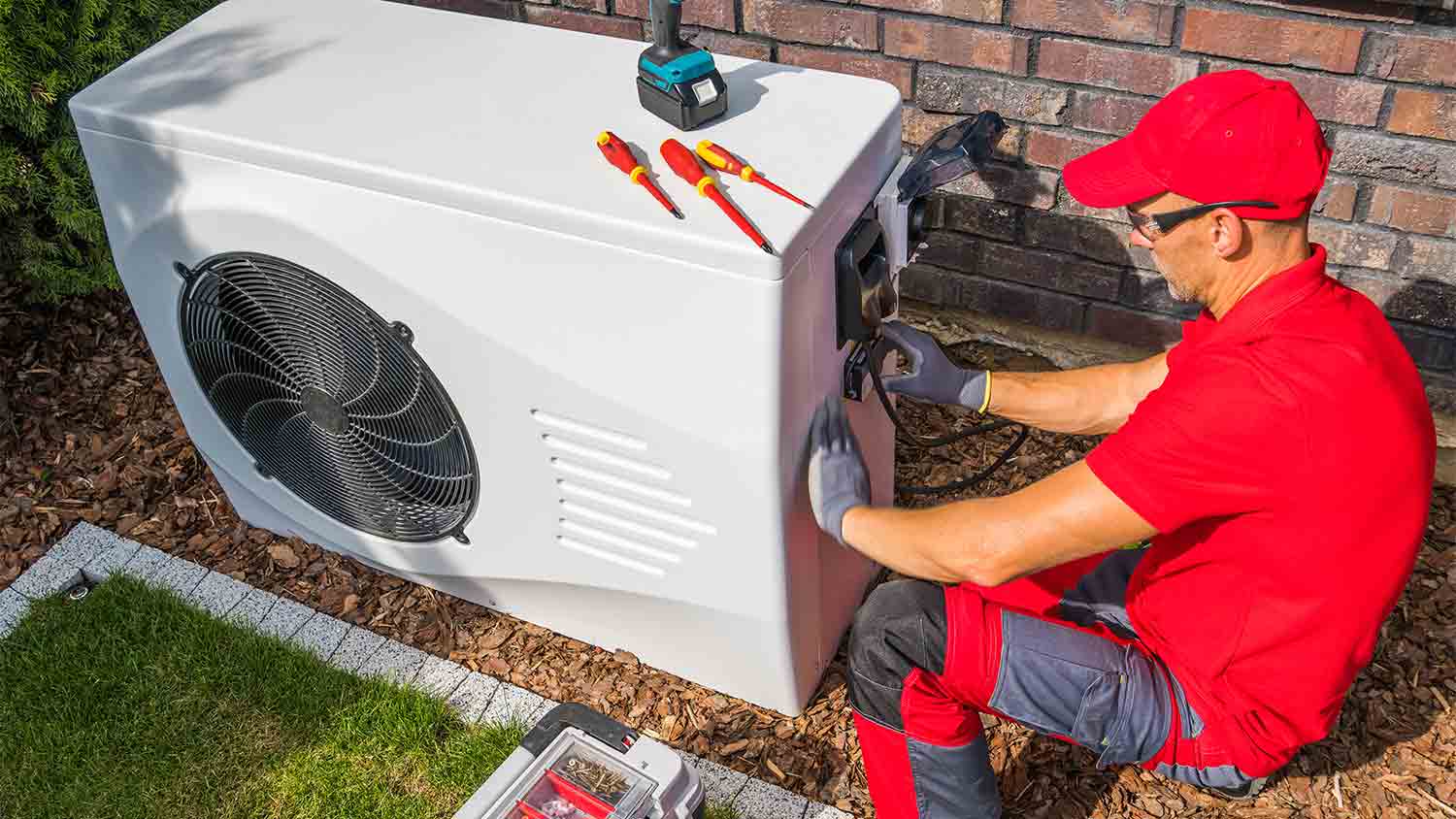 repairman fixing heat pump unit