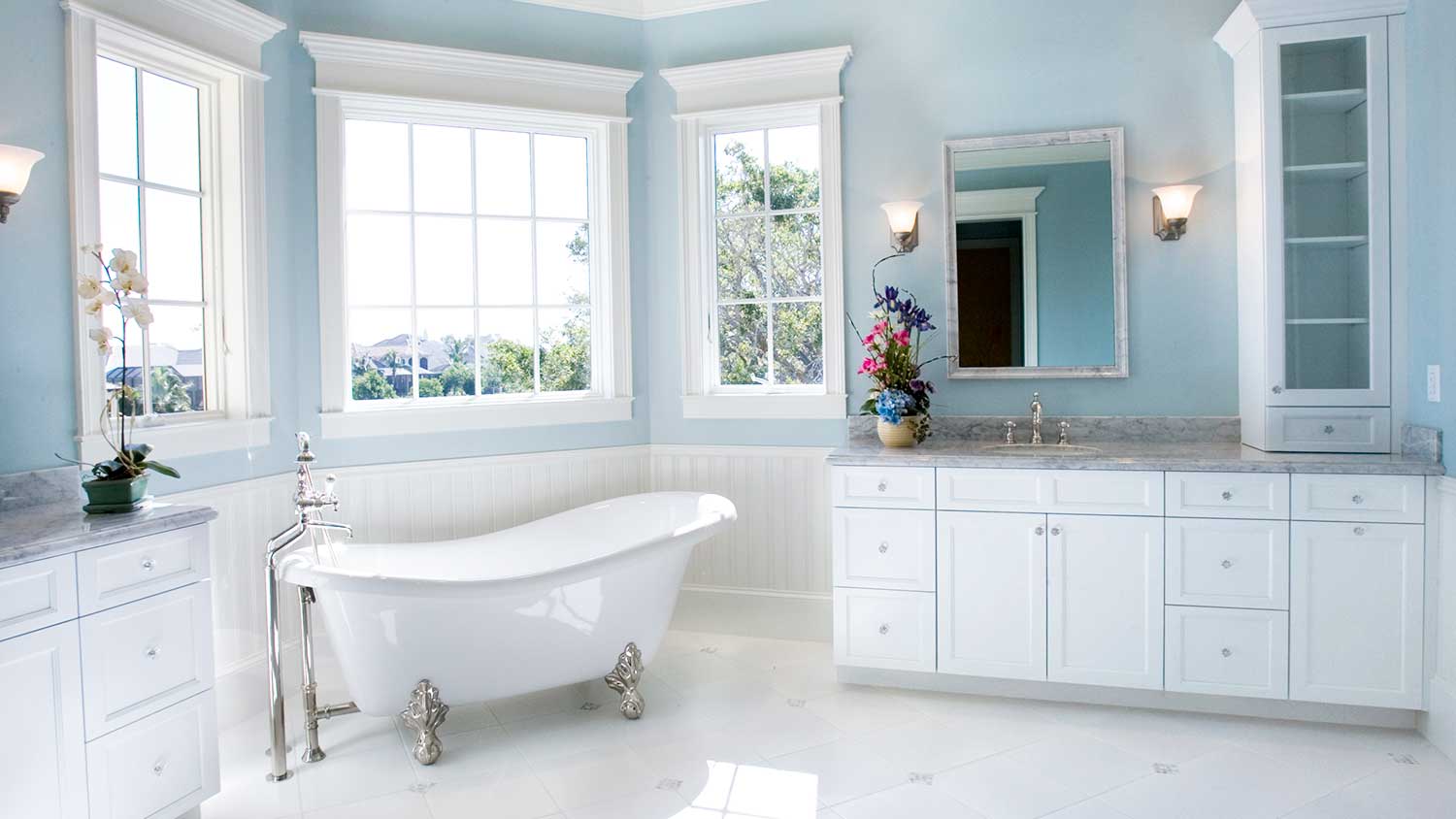 Spacious bathroom with blue walls and a clawfoot bathtub