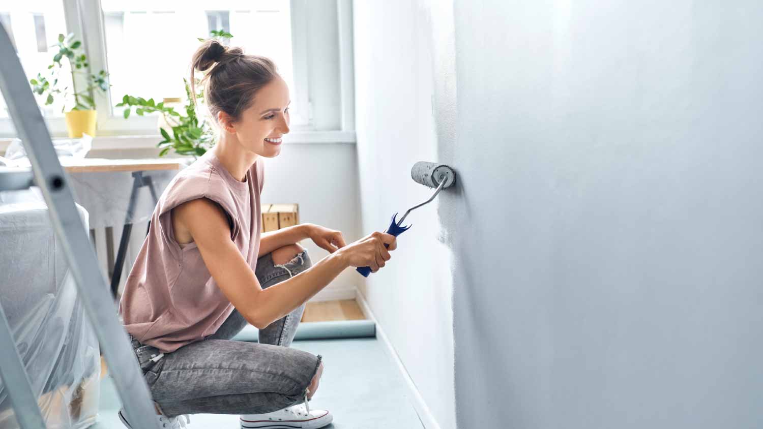 Woman painting wall with paint roller