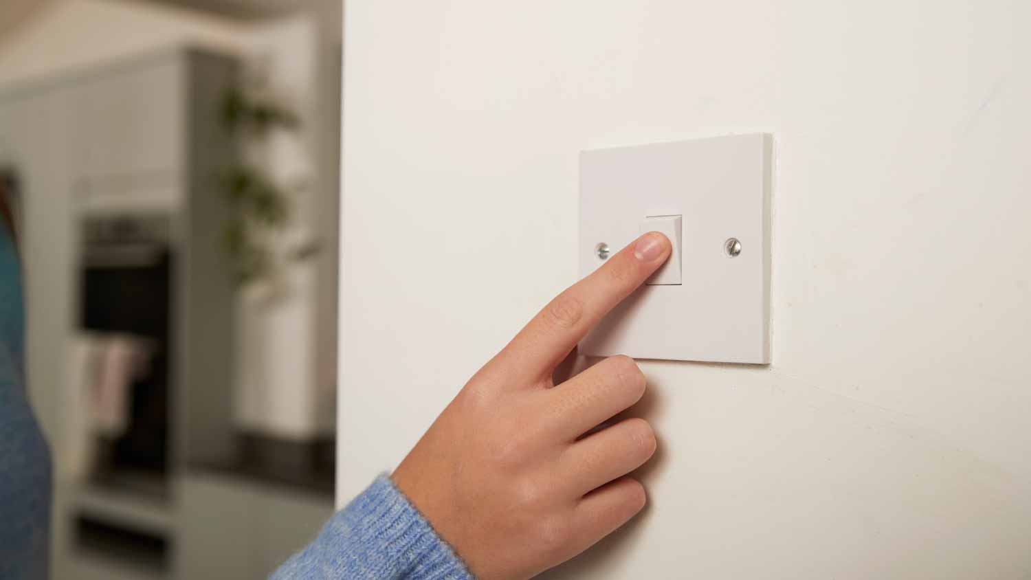 Woman turning off switch at home