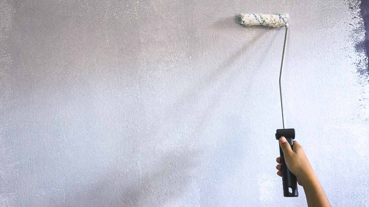 person priming grey wall