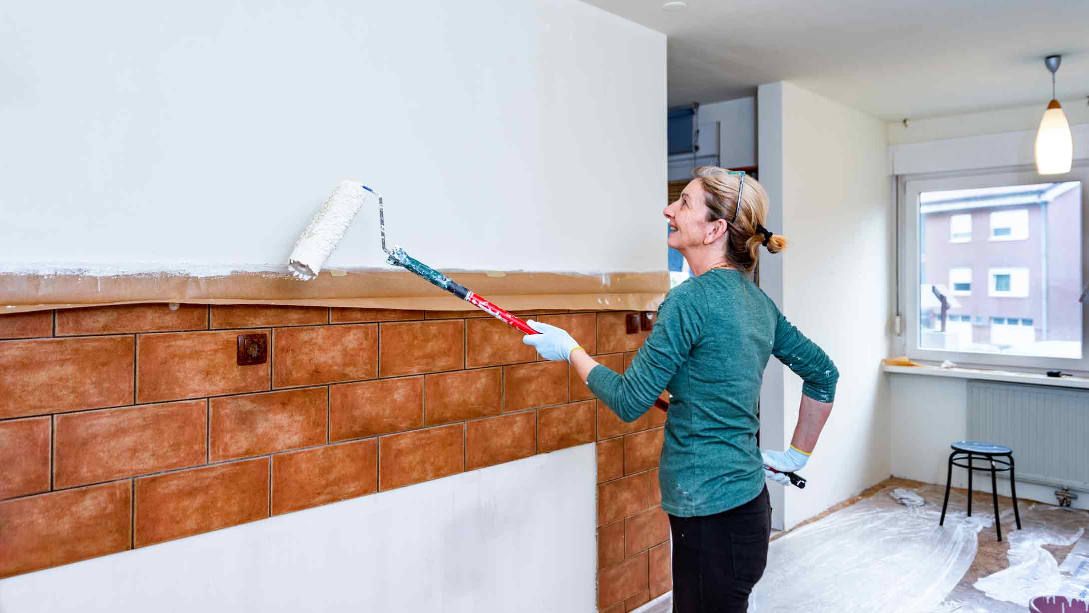 woman priming walls in the kitchen